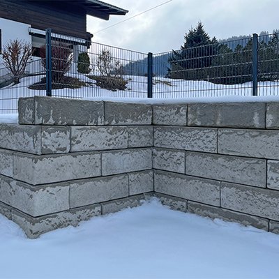 Stützmauer mit  Zaun als Gartenabgrenzung