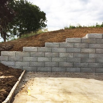 Abgestufte Stützwand aus Betonsteinen schützt Gelände am Parkplatz beim Wasserbehälter