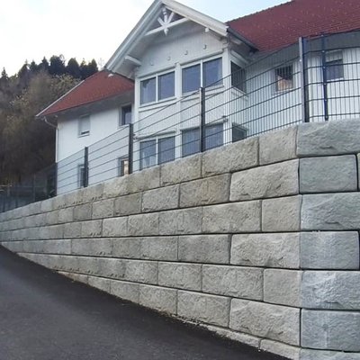 Beton-Stützmauer ersetzt verwachsene Böschung – Gartenfläche erweitert und Hang zur Straße gesichert