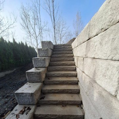 Platzsparende Stiegenlösung mit Betonstufen und massiver Hangstützmauer aus Betonblöcken