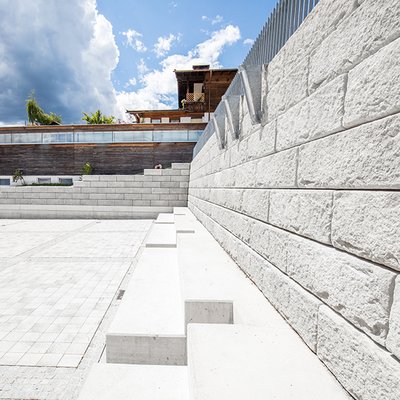 Massive Mauer mit Zaun schützt den höher gelegenen Kindergarten am neuen Gemeindeplatz