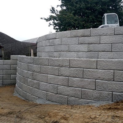 Zweifach geschwungene Stützmauer aus Betonsteinen – perfekte Lösung bei starkem Gefälle