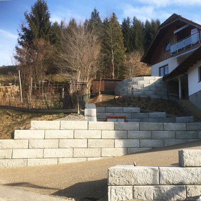 Mehrere Beton-Stützwände strukturieren den Hang – mit runder Mauer und Zufahrtsabsicherung