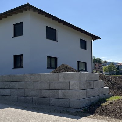 Einfamilienhaus mit Betonmauer zur Grundstücksbegrenzung